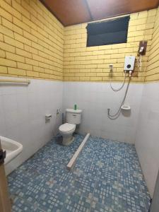 ein Badezimmer mit einem WC und einer gelben Ziegelwand in der Unterkunft Garden de Arts in Ban Na Toeng Nai