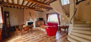 a living room with a red couch and a table at Le domaine des Roseraies in Monfréville