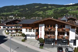 ein Hotel in einer Stadt mit einem Berg im Hintergrund in der Unterkunft Stöcklbauer in Kirchberg in Tirol
