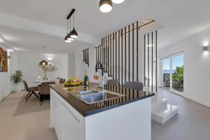 a kitchen and living room with a sink and a table at Luxury Apartments Podgora in Podgora