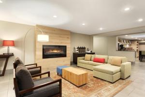 a living room with a couch and a fireplace at Country Inn & Suites by Radisson, Cedar Rapids Airport, IA in Cedar Rapids