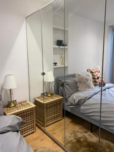 een slaapkamer met 2 bedden en een glazen wand bij Stylish Garden Flat in Londen