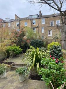 a garden in front of a large brick building at Stylish Garden Flat in London