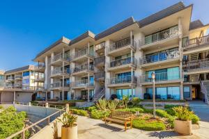 an apartment building with a bench in front of it at Del Mar Gem condo in Solana Beach