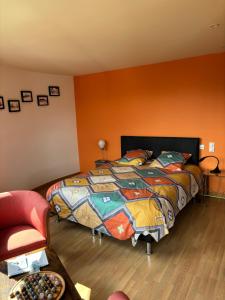 um quarto com uma cama colorida e uma cadeira em Nid de Pie em Crozon