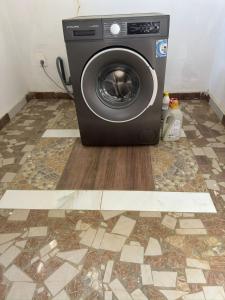 a washing machine sitting on a floor in a bathroom at Grande Villa neuve 3 chambres avec piscine et wifi à Malikounda près Saly in Malikounda