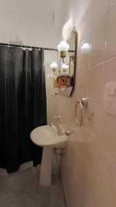 a bathroom with a sink and a black shower curtain at Hostería Suites Del Centro in Santa Rosa de Calamuchita