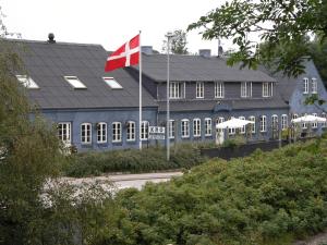 una bandera canadiense ondeando frente a un edificio en Nørre Vissing Kro, en Nørre Vissing