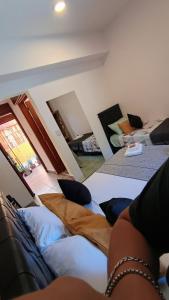 Hostería Suites Del Centro في سانتا روزا دي كالموتشيتا: شخص يجلس على سرير في غرفة