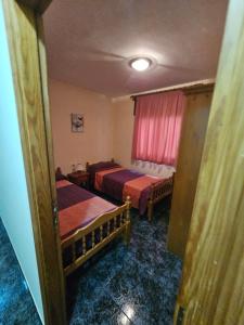 a hotel room with two beds and a window at Apartamento Mendoza-San Isidro in San Isidro