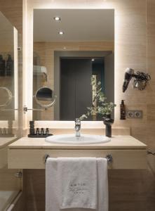 een badkamer met een wastafel en een spiegel bij Hotel Antik San Sebastián in San Sebastian