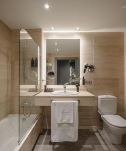 a bathroom with a sink and a toilet and a shower at Hotel Antik San Sebastián in San Sebastián