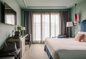a hotel room with a bed and a desk and a window at Hotel Antik San Sebastián in Donostia-San Sebastián