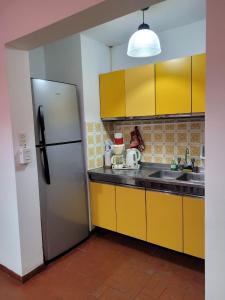 a kitchen with yellow cabinets and a stainless steel refrigerator at Mi casa vuelta de obligado 576 in Federación