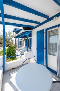 a balcony with a blue door and a table and chairs at Galini me thea in Chrissi Akti