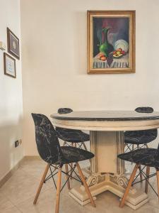 einen Tisch und Stühle in einem Zimmer mit Gemälde in der Unterkunft Flat 291 in Polignano a Mare