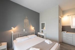 a bedroom with a white bed and a sink at Galini me thea in Chrissi Akti