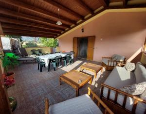 un patio esterno con tavoli e divani di Casa L' Antico Ulivo a Iglesias
