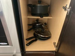 a pot and pans in a cabinet in a kitchen at Buckhead City Penthouse in Atlanta