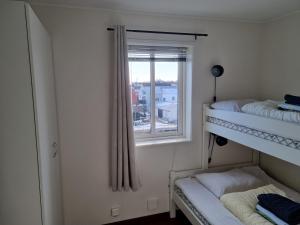 a bedroom with two bunk beds and a window at Apartment with fantastic seaview in Henningsvær. in Henningsvær