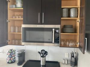 a kitchen with a microwave above a counter with utensils at Buckhead City Penthouse in Atlanta