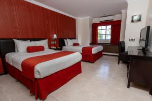 a hotel room with two beds and a flat screen tv at Hotel Ocean View in Campeche