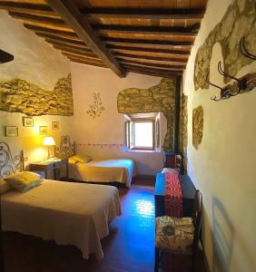 1 dormitorio con 2 camas y ventana en Borgo Petraio, en Montieri