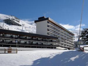 ein großes Gebäude im Schnee mit einem Berg in der Unterkunft Appartement Les Menuires, 3 pièces, 8 personnes - FR-1-344-1037 in Les Menuires
