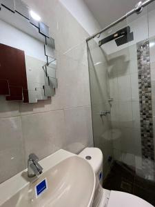 a bathroom with a toilet and a sink and a shower at Hotel Coffee Real Pereira in Pereira