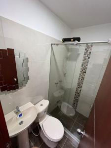 een badkamer met een toilet, een wastafel en een douche bij Hotel Coffee Real Pereira in Pereira