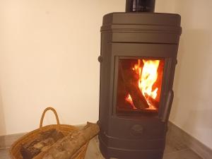 a wood stove with a fire in a room at La Barraca de Ro-Casa en el campo con piscina-50 kilimetros de la playa in La Ñora