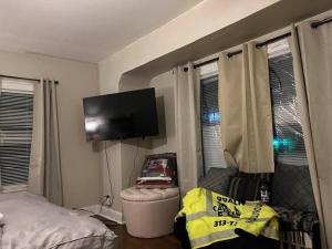 a bedroom with a bed and a flat screen tv at Marygrove Manor in Detroit