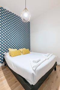 Bett mit gelben Kissen in einem Zimmer in der Unterkunft Logement au centre de Strasbourg in Straßburg