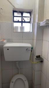 uma pequena casa de banho com WC e janela em Ample Residence em Nairobi