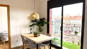 a dining room with a table and a large window at APARTAMENTO CON TERRAZA BY PRESTIGI in Terrassa