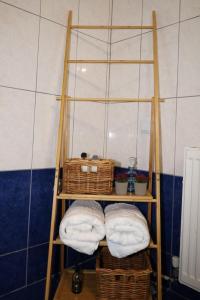 a towel shelf with baskets and towels in a bathroom at The Seashell apartment in Keramotí