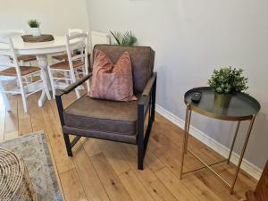 a chair with a pillow on it next to a table at Pet-friendly 2 bed home near Chester train station. For 6 people. in Chester