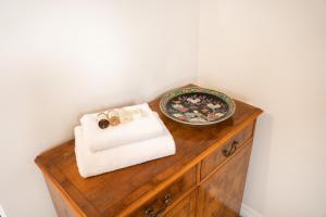 a wooden cabinet with a towel and a plate on it at Pet-friendly 2 bed home near Chester train station. For 6 people. in Chester