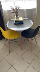uma mesa com duas cadeiras e uma mesa com livros sobre ela em Ample Residence em Nairobi