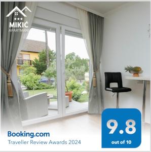 Zimmer mit einem Fenster, einem Stuhl und einem Schreibtisch. in der Unterkunft Apartmani Mikic in Palić