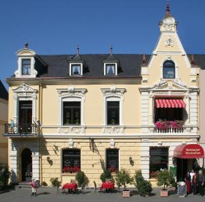 ein großes gelbes Gebäude mit einem Uhrturm oben in der Unterkunft Hotel Sankt Maximilian in Bernkastel-Kues