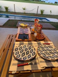 einem Picknicktisch aus Holz mit Essen darüber in der Unterkunft Casa de Campo RSC XIII - Represa Jurumirim - SP in Paranapanema