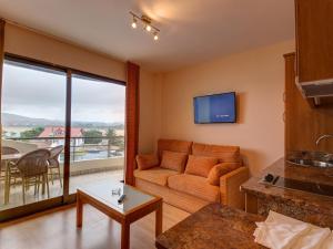 sala de estar con sofá y TV en Apartamentos Astuy, en Isla