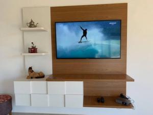 einen TV an der Wand mit einer Person auf einem Surfbrett in der Unterkunft Casa de Campo RSC XIII - Represa Jurumirim - SP in Paranapanema