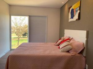 ein Schlafzimmer mit einem Bett mit zwei Kissen und einem Fenster in der Unterkunft Casa de Campo RSC XIII - Represa Jurumirim - SP in Paranapanema