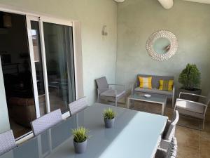 - un salon avec une table et des chaises blanches dans l'établissement La Maison du Courtil, Amande-Olive, à Moustiers-Sainte-Marie