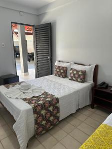 a bedroom with a large bed with a table at Pousada Aguas Quentes in Barra do Garças