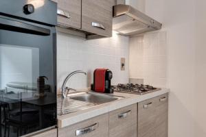 a kitchen with a sink and a red appliance at Comfort Scandicci Centro Facile accesso a Firenze in Scandicci