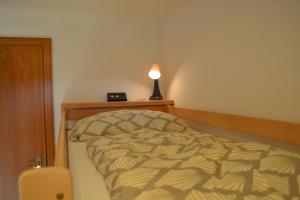 Schlafzimmer mit einem Bett und einer Lampe auf einem Tisch in der Unterkunft Apartment Weitblick in Bad Waltersdorf
