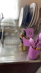 a dish drying rack with plates and utensils at Ample Residence in Nairobi